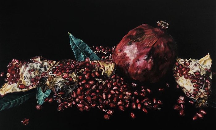 realistic drawing of a still life of a pomegranate made with caran d'ache luminance colored pencils